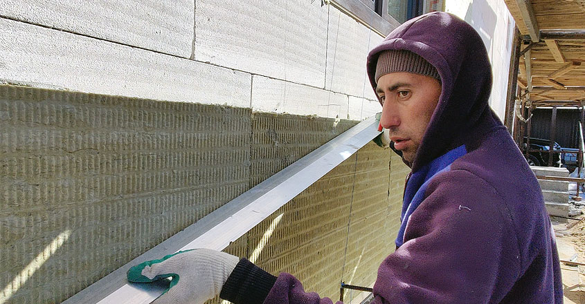 Процесс отделки поверх утеплителя фасада дома из газобетона
